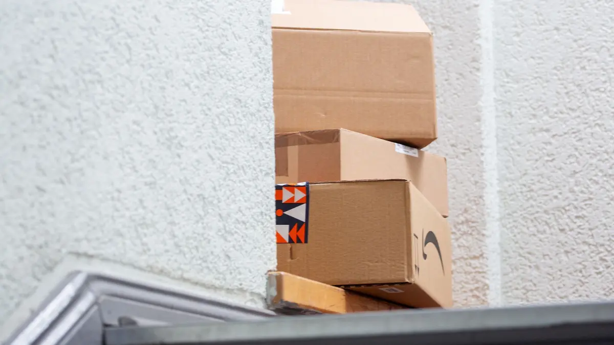 Paketbranche: ILLUSTRATION - 24.11.2025, Berlin: Mehrere Pakete stehen im Eingangsbereich eines Wohnhauses aufeinander gestapelt. Amazon erhöht seinen Beschäftigten in Deutschland die Löhne. (zu dpa: «Amazon zahlt Mitarbeitern mehr Geld - Verdi bleibt kritisch») Foto: Fernando Gutierrez-Juarez/dpa +++ dpa-Bildfunk +++