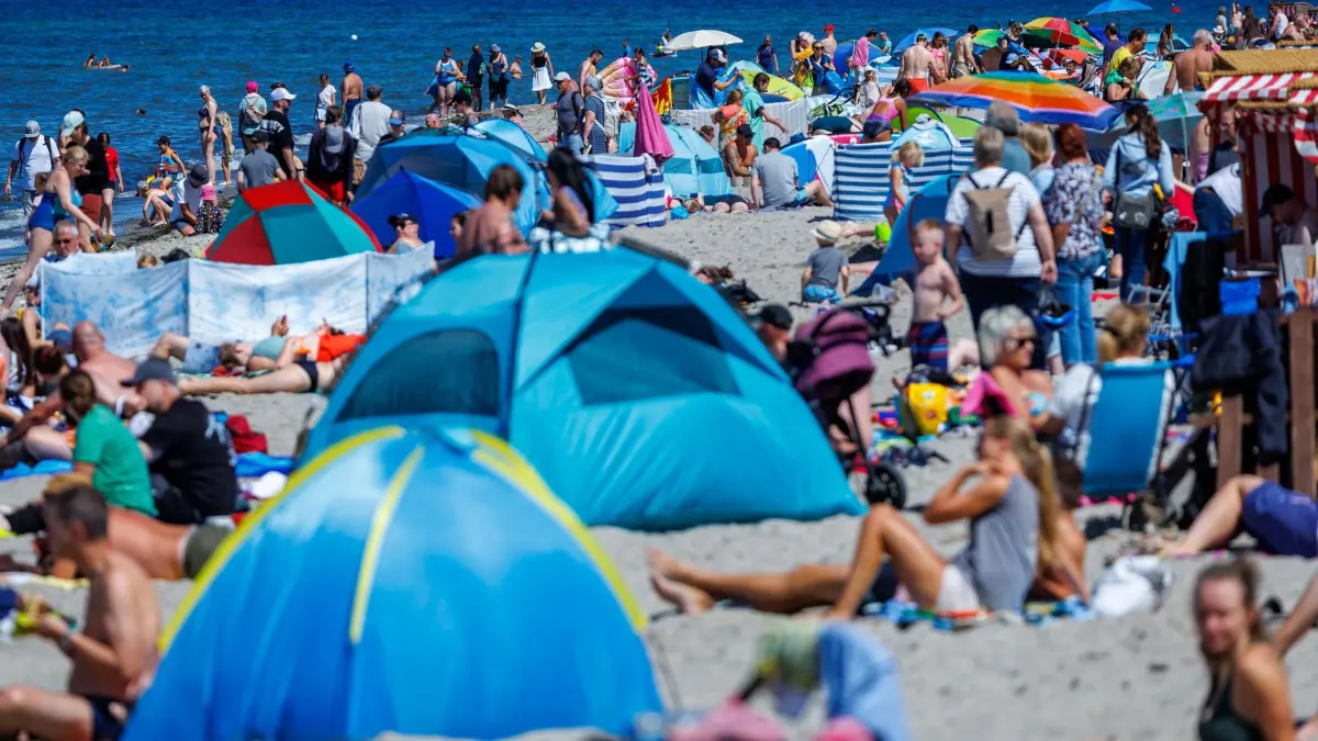 Volle Strände an der Ostseeküste: 21.07.2026, Mecklenburg-Vorpommern, Timmendorf (Poel): Urlauber und Tagesgäste nutzen das warme und sonnige Wetter zu einem Strandbesuch an der Küste auf der Ostseeinsel Poel. Das Sommerwetter zeigt sich in Norddeutschland von seiner freundlichen Seite. Foto: Jens Büttner/dpa +++ dpa-Bildfunk +++