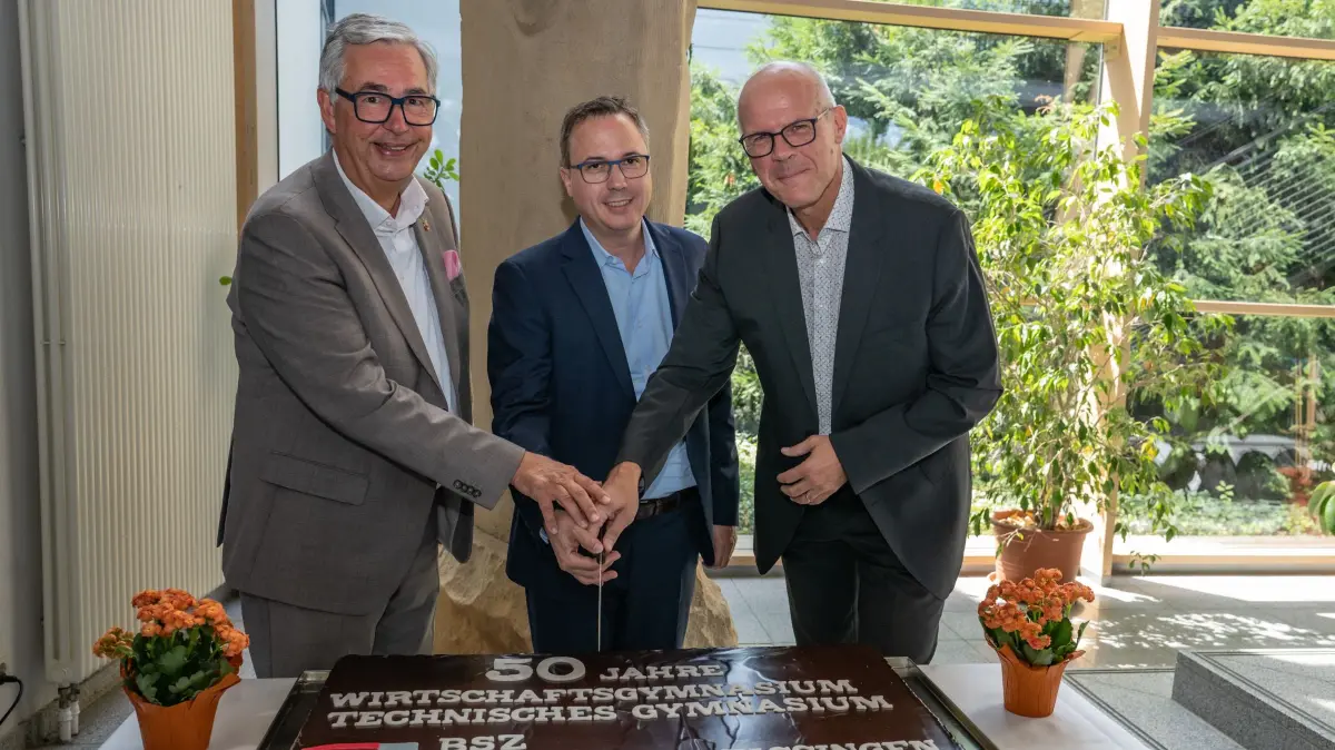 Landrat Dietmar Allgaier, Staatssekretär Andreas Deuschle (MdL) und Schulleiter Stefan Ranzinger (v.li.) schneiden die Torte zum 50. Geburtstag des Beruflichen Gymnasiums an.