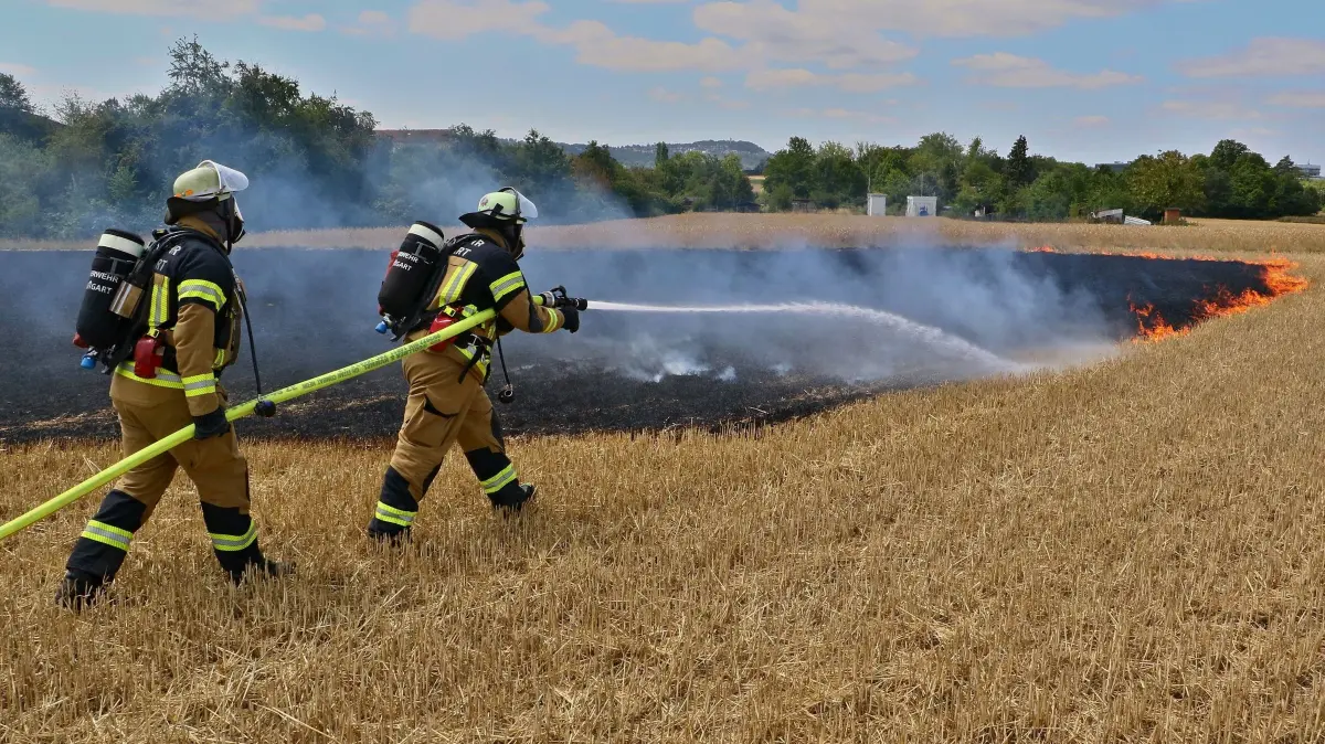 23.07.2026: Am Donnerstagnachmittag gegen 13:15 Uhr geriet auf ein Stoppelacker in Stuttgart-Hausen in Brand. Auf einer Fläche von rund 50x80 Metern brannte das abgeerntete Feld zwischen der Straße "Beim Fasanengarten" und dem Ditzinger Industriegebiet.Gartenbesitzer unternahmen vor dem Eintreffen der Feuerwehr erste Löschmaßnahmen mit einer Gießkanne. Die angrenzende Montessori-Grundschule wurde auf Grund der Rauchentwicklung geräumt und die Schüler auf den Sammelplatz geführt. Mit drei C-Rohren konnten die Freiwillige Feuerwehr Weilimdorf und die Einheiten der Feuerwache 4 Feuerbach das Feuer ablöschen und ein Übergreifen auf angrenzende Kleingärten verhindern.Um ausreichend Wasser zur Verfügung zu haben musste eine rund 250 Meter lange Schlauchleitung zum nächsten (funktionierenden) Hydranten verlegt werden.
Foto: KS-Images.de/Andreas Rometsch