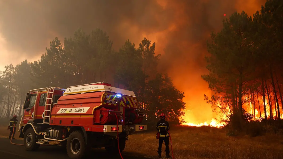 Brände in Frankreich: 23.07.2026, Frankreich, Le Porge: Feuerwehrleute versuchen in der Nähe von Le Porge im Südwesten Frankreichs mit einem Waldbrandlöschfahrzeug, die brennenden Bäume zu löschen. Foto: Romain Perrocheau/AFP/dpa +++ dpa-Bildfunk +++