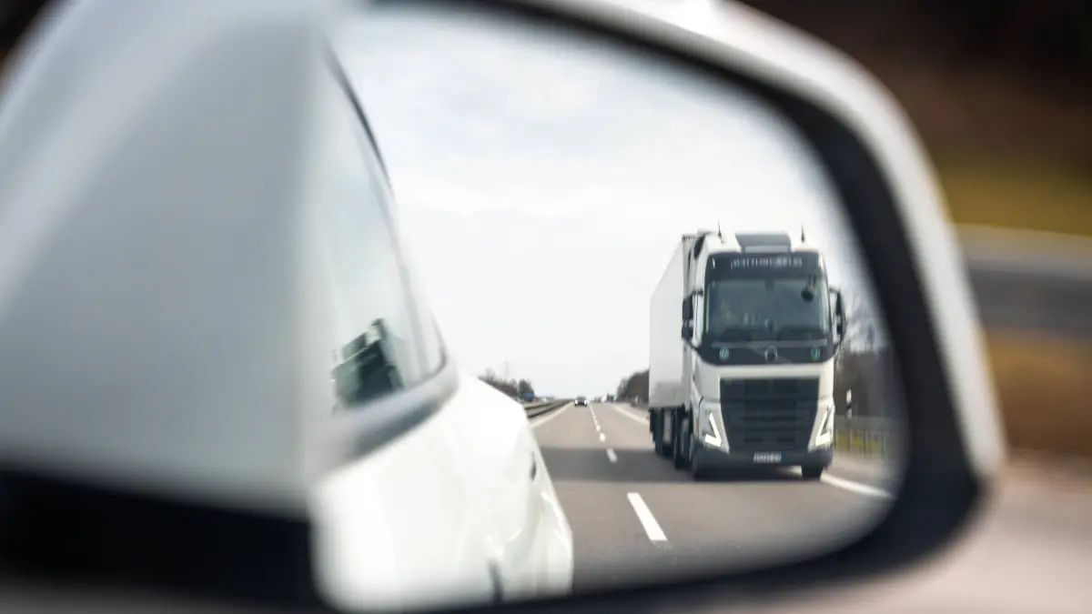 Memmingen, Bavaria, Germany - February 28, 2026: A truck in the rearview mirror while a car overtakes on the highway. The scene illustrates typical traffic situations with potential hazards due to lane changes, speed, and limited visibility in road traffic. *** Ein Lkw im Rückspiegel während ein Pkw auf der Autobahn überholt. Die Szene verdeutlicht typische Verkehrssituationen mit potenzieller Gefahr durch Spurwechsel, Geschwindigkeit und eingeschränkte Sicht im Straßenverkehr.