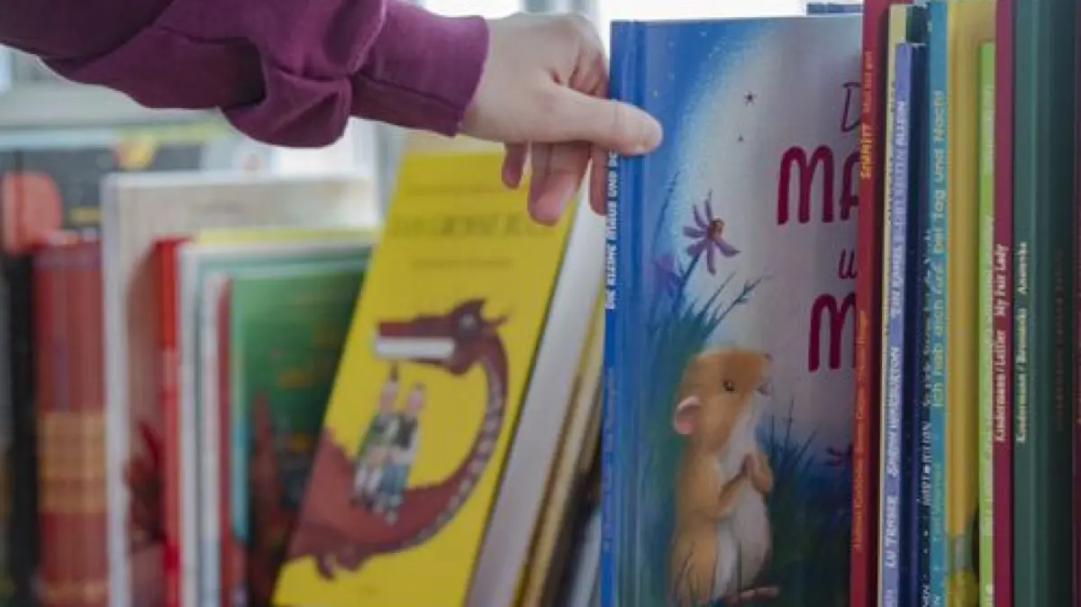 ARCHIV - 02.04.2022, Berlin: Eine Frau greift vor dem Start des Vorlese-Weltrekordversuchs der LeseLounge e.V. nach einem Kinderbuch. Der Vorlese-Marathon findet in der Zentrale des rbb Rundfunk Berlin-Brandenburg statt.
Das richtige Buch zu finden, ist gar nicht einfach. Manchmal können die Mitarbeitenden in Büchereien bei der Auswahl helfen. (zu dpa: «Das neue Lieblingsbuch finden») Foto: Paul Zinken/dpa - Honorarfrei nur für Bezieher des Dienstes dpa-Nachrichten für Kinder +++ dpa-Nachrichten für Kinder +++