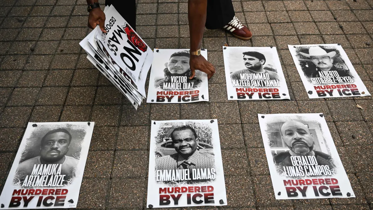 US-POLITICS-DEMONSTRATION: A protester holds portraits of people killed by US Immigration and Customs Enforcement (ICE) during a protest over the killing of Mexican migrant Lorenzo Salgado Araujo in downtown Houston, Texas, on July 28, 2026. Araujo was fatally shot by a US immigration officer on July 14. (Photo by RONALDO SCHEMIDT / AFP)