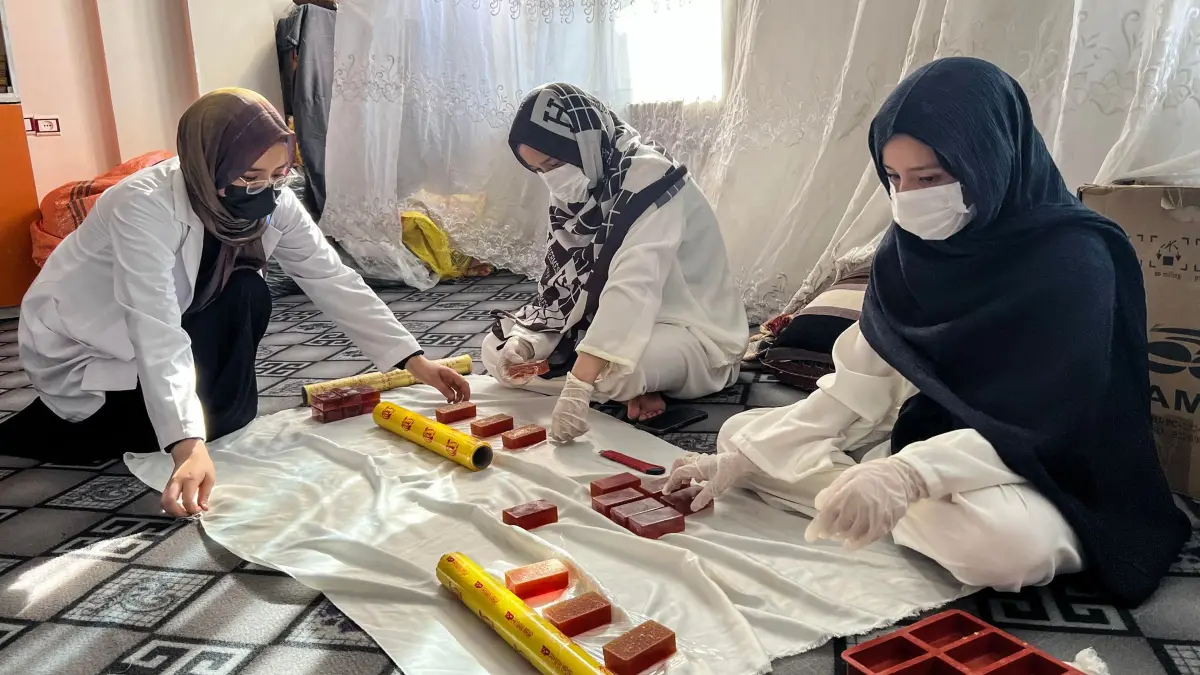 Seifenfabrik in Afghanistan: 28.07.2026, Afghanistan, Herat: Roqia Rezai (l) verpackt Seife mit ihren Schwestern in ihrer Seifenfabrik. Foto: Fardina Akbari/dpa +++ dpa-Bildfunk +++