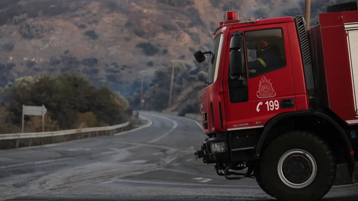Waldbrände in Griechenland - Kreta: 29.07.2026, Griechenland, Kreta: Ein Feuerwehrmann fährt während eines Waldbrands in der Region Rethymno auf der südgriechischen Insel Kreta ein Feuerwehrauto. Foto: Giannis Angelakis/AP/dpa +++ dpa-Bildfunk +++