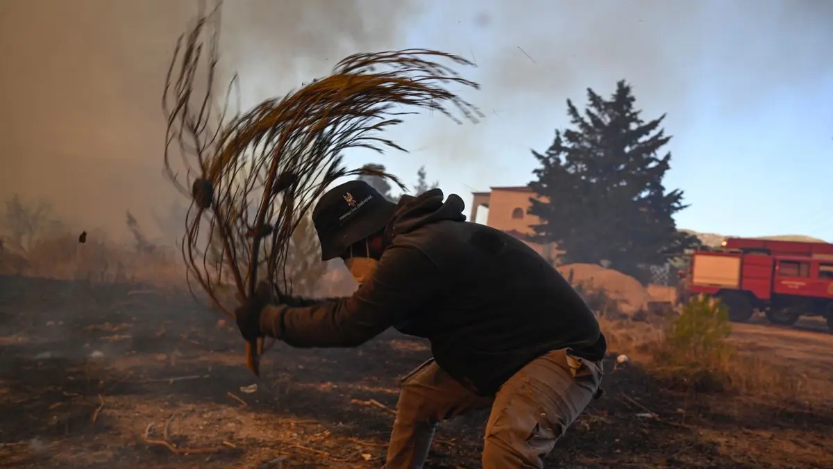 Ein Freiwilliger versucht bei einem Waldbrand in der Nähe von Porto Germeno kleine Flammen zu löschen.