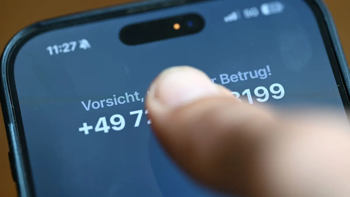 Abzocke-Anrufe: PRODUKTION - 21.05.2026, Nordrhein-Westfalen, Düsseldorf: Ein Mann hält ein Smartphone in der Hand, auf dem gerade ein Anruf eines mutmaßlichen Betrügers eingeht. (zu dpa: «Falscher Kriminalbeamter betrügt 86-Jährige um 15.000 Euro») Foto: Wolf von Dewitz/dpa +++ dpa-Bildfunk +++