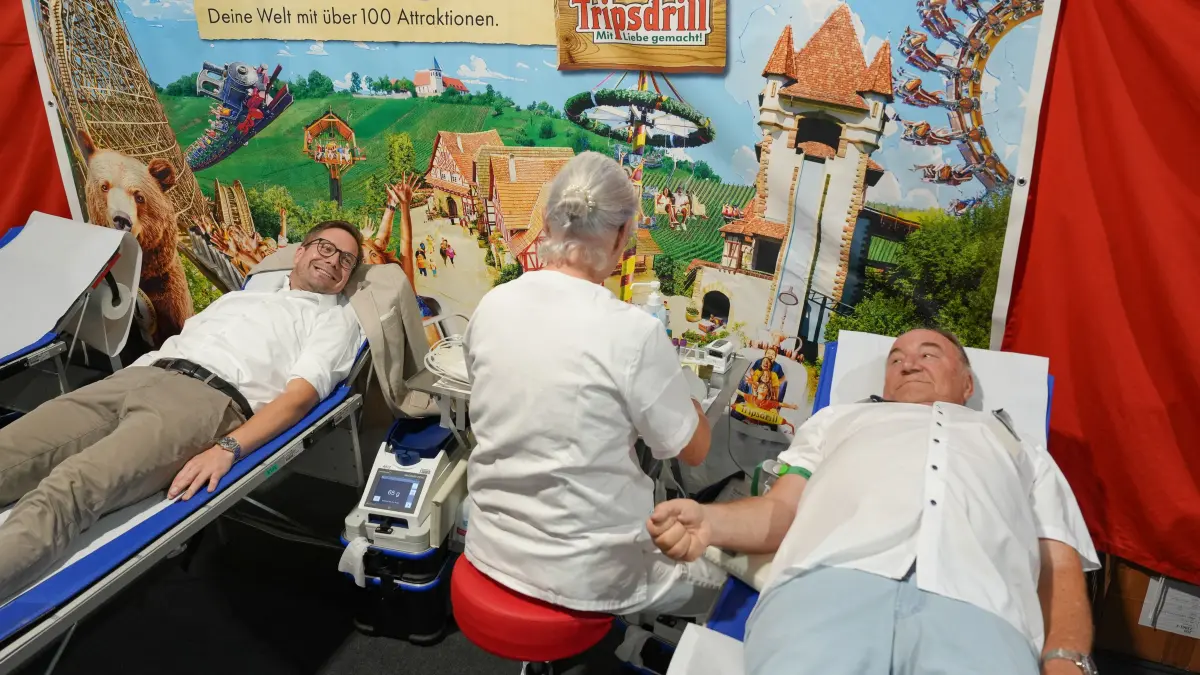 Bundestagsabgeordneter Fabian Gramling (links) und Tripsdrill-Geschäftsführer Helmut Fischer (rechts) spenden bei der Eröffnung Blut