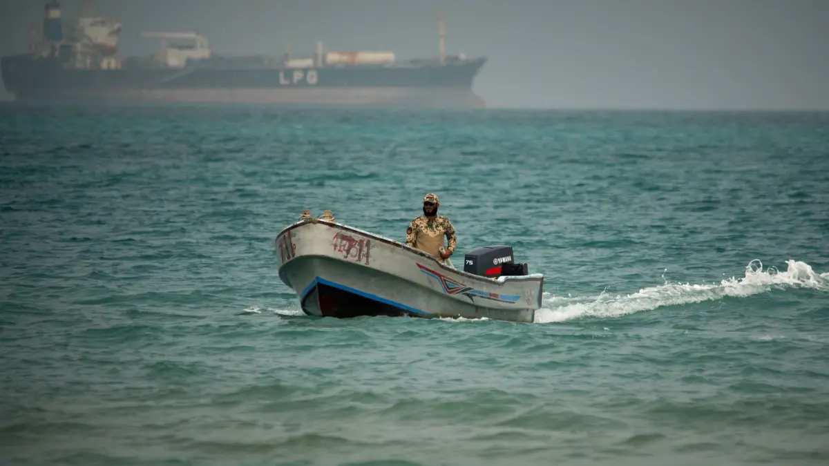 Iran-Krieg - Jemen: ARCHIV - 06.04.2026, Jemen, Mokha: Vor dem Hintergrund eines LPG-Tankers (Flüssiggas) fährt ein jemenitischer Soldat in den Gewässern nördlich der Straße von Bab el-Mandeb. (zu dpa: «Schiff vor Jemens Küste mit Seedrohne angegriffen») Foto: Abdulnasser Alseddik/AP/dpa +++ dpa-Bildfunk +++