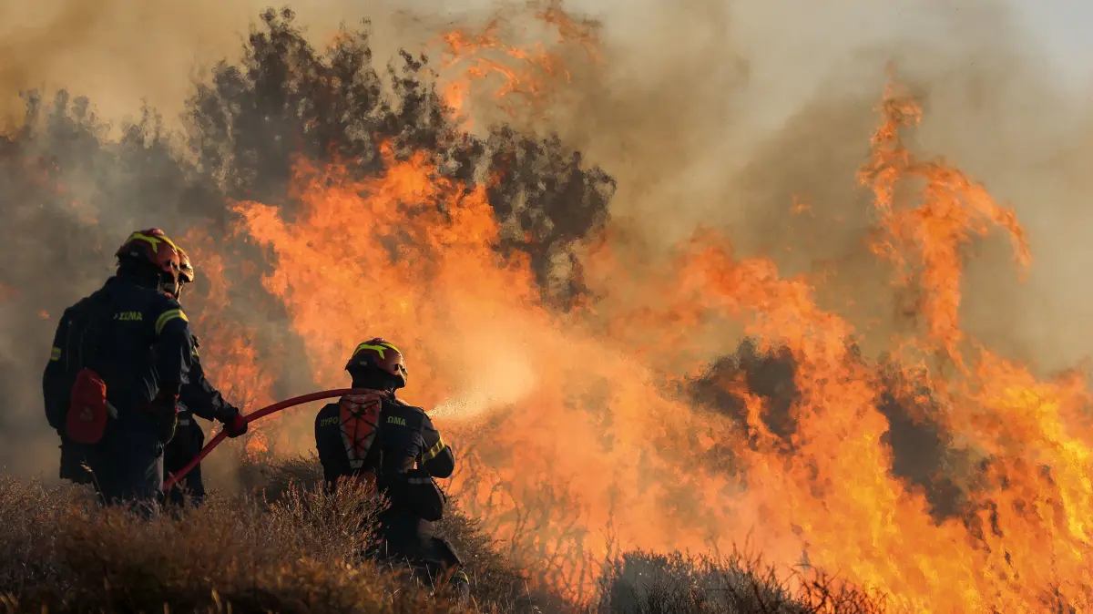 Feuerwehrleute bekämpfen die Flammen, die in der Nähe von Ierapetra auf der Insel Kreta Wälder und Ackerland verbrennen.