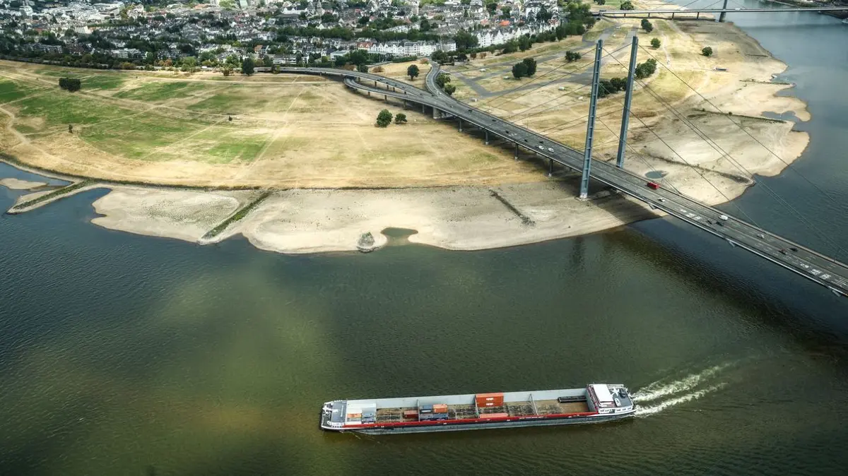 Ein Containerschiff fährt mit geringer Ladung bei Niedrigwasser am Rheinknie in der nordrhein-westfälischen Landeshauptstadt vorbei.