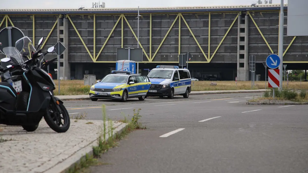 Verdächtiger Fund am Flughafen Leipzig: 05.08.2026, Sachsen, Leipzig/Halle: Zwei Einsatzfahrzeuge der Polizei stehen beim Flughafen Leipzig/Halle. Der Flughafen Leipzig/Halle hat in der Nacht den Flugbetrieb eingestellt, nachdem ein unbekanntes Flugobjekt und zugleich ein verdächtiger Gegenstand gefunden wurden. Foto: Tobias Junghanns/dpa +++ dpa-Bildfunk +++