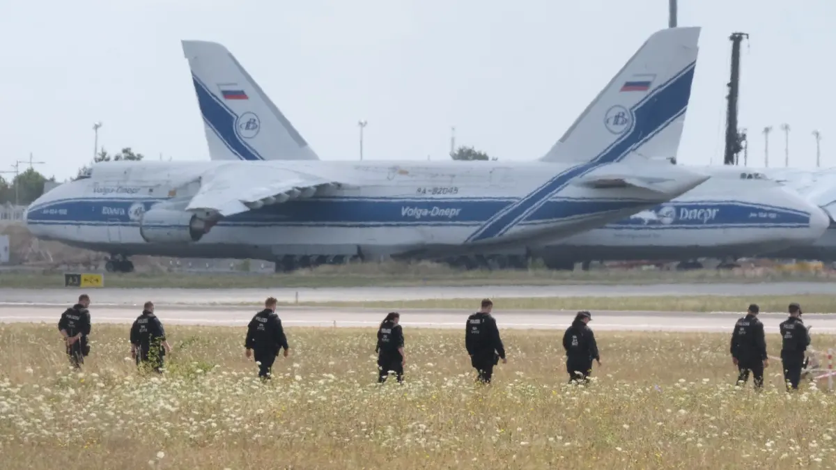Polizei sucht zweite Drohne: 07.08.2026, Sachsen, Schkeuditz: Polizisten gehen über eine Wiese auf dem Gelände des Flughafen-Leipzig. Die Ermittlungen nach der Entdeckung der Sprengstoff-Drohne dauern an. An der nördlichen Rollbahn sind zahlreiche Polizistinnen und Polizisten im Einsatz und suchen das Gelände zu Fuß ab. Foto: Sebastian Willnow/dpa +++ dpa-Bildfunk +++