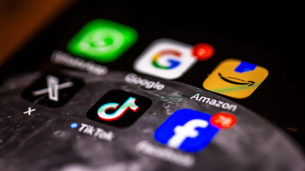 Apps auf Smartphone: ILLUSTRATION - 10.04.2025, Mecklenburg-Vorpommern, Schwerin: Die Apps verschiedener US-amerikanischer Tech-Konzerne, WhatsApp, Google, Amazon, X und Facebook, sind gemeinsam mit der chinesischen App TikTok auf dem Display eines Smartphones zu sehen. (zu dpa: «EU-Kommissarin gibt Tech-Riesen Mitschuld an Migrationskrise in Ceuta») Foto: Jens Büttner/dpa +++ dpa-Bildfunk +++