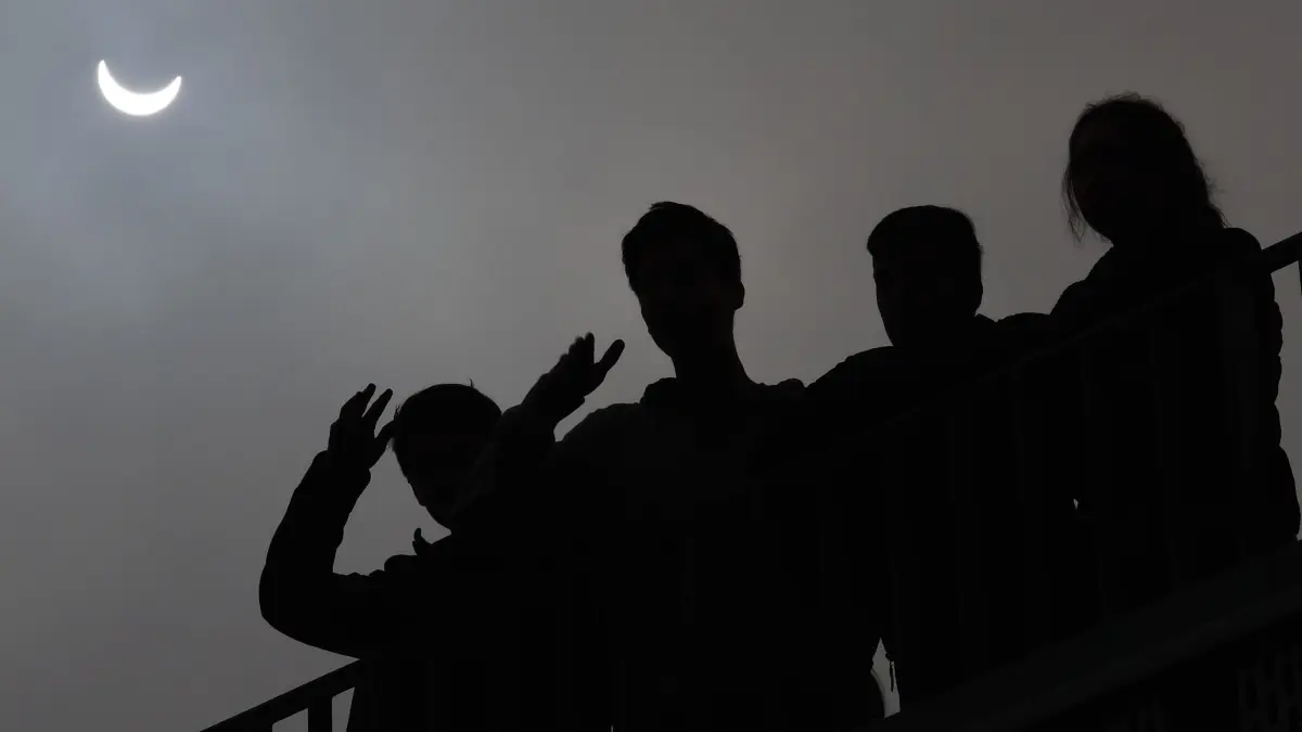 Schüler beobachten die Sonnenfinsternis 2015 in Kassel: ARCHIV - Partielle Sonnenfinsternisse gibt es häufiger - dieses Bild wurde 2015 in Kassel gemacht. Solche Aussichten kann es am 12. August auch in Deutschland geben, denn hierzulande schiebt sich der Mond zumindest teilweise vor die Sonne. (zu dpa: «Totale Sonnenfinsternis: Hotspots für Reisende») Foto: Uwe Zucchi/dpa/dpa-tmn - Honorarfrei nur für Bezieher des dpa-Themendienstes +++ dpa-Themendienst +++