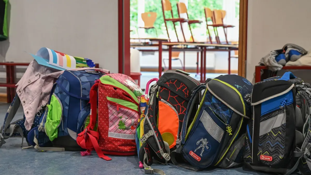 Schulranzen: ARCHIV - 15.07.2021, Hessen, Wiesbaden: Schulranzen stehen vor einem Klassenzimmer. (zu dpa: «Schulstart für die Erstklässler») Foto: Arne Dedert/dpa +++ dpa-Bildfunk +++