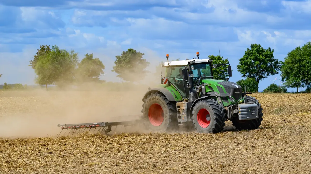Trockenheit in der Landwirtschaft: 11.08.2026, Brandenburg, Podelzig: Ein Landwirt bearbeitet mit seinem Traktor und einem Striegel ein abgeerntetes Getreidefeld und wirbelt dabei viel Staub vom trockenen Boden auf. Foto: Patrick Pleul/dpa +++ dpa-Bildfunk +++