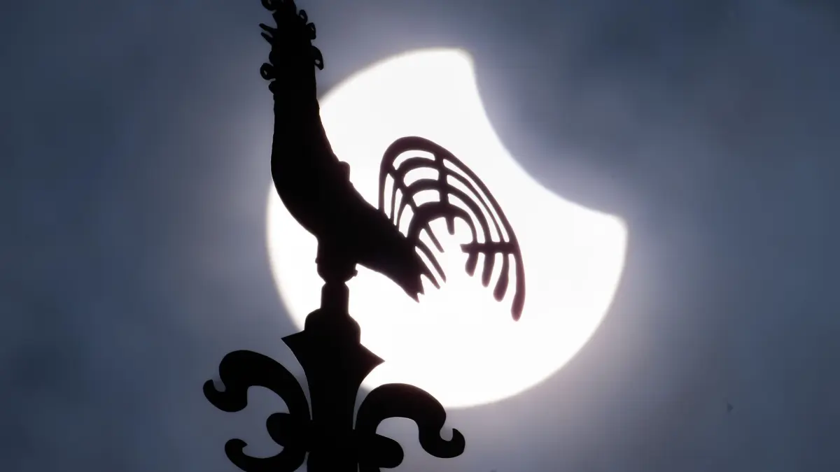 Partielle Sonnenfinsternis: ARCHIV - 29.03.2025, Hessen, Frankfurt/Main: Die zum Teil durch den Mond verdeckte Sonne steht hinter dem Wetterhahn der Kreuzkirche in Frankfurt-Preungesheim am Himmel. (zu dpa: «Klare Sicht auf die Sonnenfinsternis in Hessen») Foto: Boris Roessler/dpa +++ dpa-Bildfunk +++