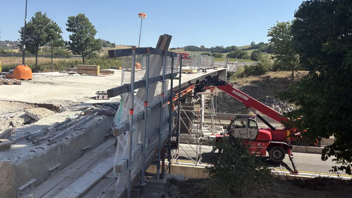 Ein Baustellenfahrzeug arbeitet nach dem Unfall an der Brücke.