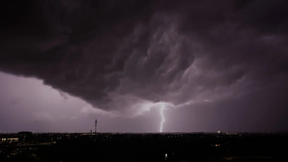 Unwetter in Kansas (Symbolbild).: ARCHIV - 13.04.2026, USA, Lenexa: Blitze zucken im April in Lenexa, Kansas, während in der Ferne ein Gewitter vorbeizieht.(Symbolbild). (zu dpa: «Blitz bei US-Gefängnis - 16 Häftlinge ins Hospital gebracht») Foto: Charlie Riedel/AP/dpa +++ dpa-Bildfunk +++