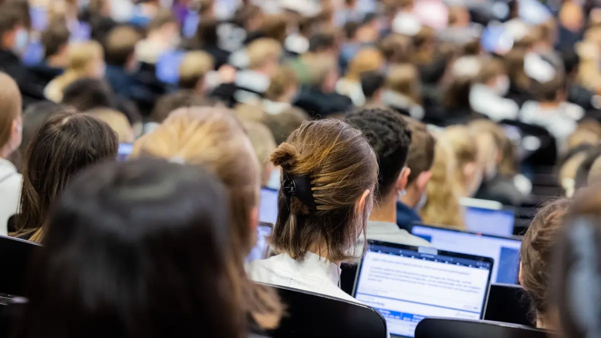 Wie man das passende Studium in NRW findet: ARCHIV - 11.10.2021, Nordrhein-Westfalen, Münster: Studentinnen und Studenten sitzen während einer Vorlesung in einem Hörsaal der Universität Münster. Studieninteressierte in Nordrhein-Westfalen können seit kurzem auf einer einzigen Plattform Informationen über mehr als 2.000 grundständige Studiengänge an 65 Hochschulstandorten in Nordrhein-Westfalen abrufen. (zu dpa: «Wie man das passende Studium in NRW findet») Foto: Rolf Vennenbernd/Deutsche Presse-Agentur GmbH/dpa +++ dpa-Bildfunk +++