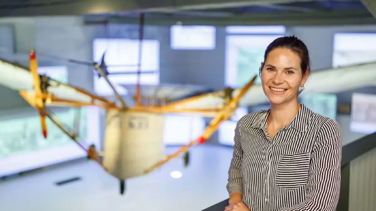 Museumsleiterin Laura Gebauer vor dem Nachbau des vielleicht ersten Motorflugzeugs der Welt.