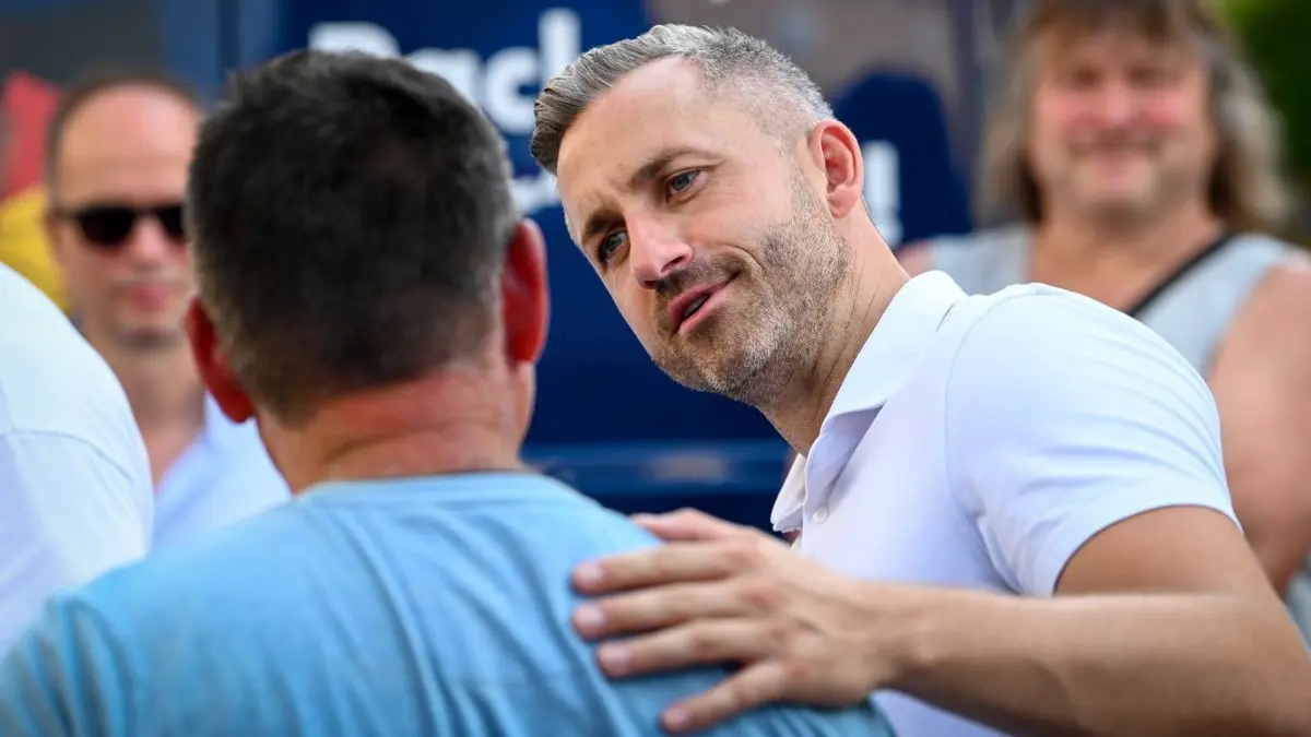 Der gefährlichste Mann Deutschlands?“ Ulrich Siegmund (Mi.), Spitzenkandidat der AfD für die Landtagswahl in Sachsen-Anhalt, reagiert am 5. August 2026 beim Bürgerdialog an einem Infostand in Wittenberg.
