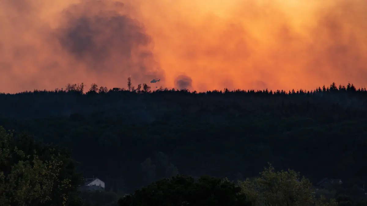 Waldbrand Deutschland NRW: Waldbrand Deutschland NRW 15.08.2026, Germany, Nordrhein- Westfahlen, Hürtgenwald, Düren, Klima , Sommer, Hitze, Brand, Waldbrand Seit 3 Tagen bedroht auf einer Fläche von 7 ha ein immer wieder aufflmmender Waldbrand 6 Gemeinden mit 11 000 Einwohnern, hier das Feuer von Hürtgenwald über dem Horizint, Die Rauchwolken bedecken das komplette Dürener und Zülpicher Becken. Das alles 7 km Luftlinie vom Braunkohle Tagebau Inden. Hier Lösch Hunbschrauber über riesigem Waldbrandgebiet, ein Tropfen bei den neuen Winden auf den heissen Waldboden  Hürtgenwald Nordrhein-Westfahlen Germany *** Forest Fire Germany NRW August 15, 2026, Germany, North Rhine-Westphalia, Hürtgenwald, Düren, Climate, Summer, Heat, Fire, Forest Fire For the past 3