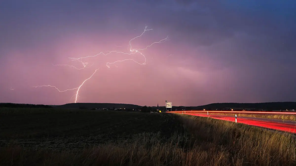 Gewitter in Bayern: 16.08.2026, Bayern, Aurach: Blitze zucken bei einem abendlichen Gewitter über Mittelfranken. Foto: Alexander Wolf/onw-images/dpa +++ dpa-Bildfunk +++