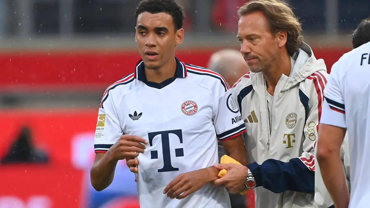Fussball Testpiel / 1.FC Heidenheim - FC Bayern Muenchen 2-5: Jamal MUSIALA Bayern Muenchen bricht erneut zusammen,Ohnmacht, wird von Dr.Peter UEBLACKER Mannschaftsarzt FCB vom Platz gefuehrt, Fussball Testpiel / 1.FC Heidenheim - FC Bayern Muenchen 2-5 am 18.08.2025 , VOITH ARENA. *** Jamal MUSIALA of Bayern Munich collapses again he faints and is led off the field by Dr. Peter UEBLACKER, the FCB team doctor, during a soccer exhibition match between 1. FC Heidenheim and FC Bayern Munich 25 on August 18, 2025, VOITH ARENA