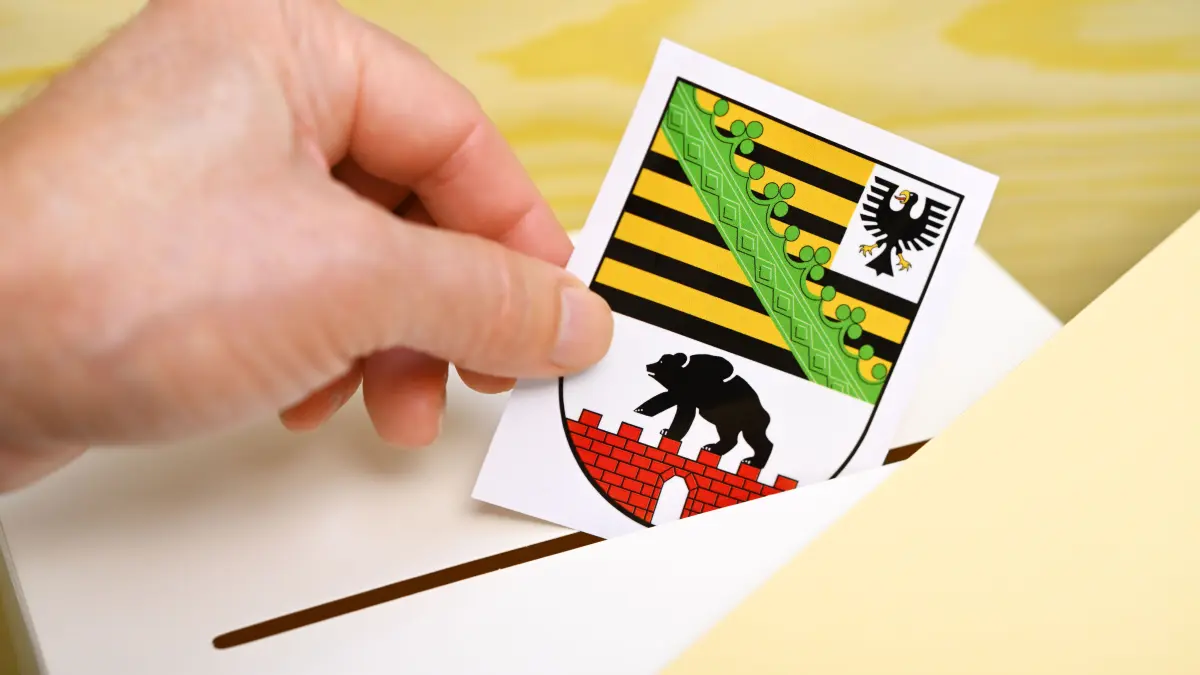 Symbolfoto Landtagswahl in Sachsen-Anhalt: Hand wirft Landeswappen des deutschen Bundeslandes Sachsen-Anhalt in eine Wahlbox, Symbolfoto Landtagswahl +++ nur redaktionelle Nutzung