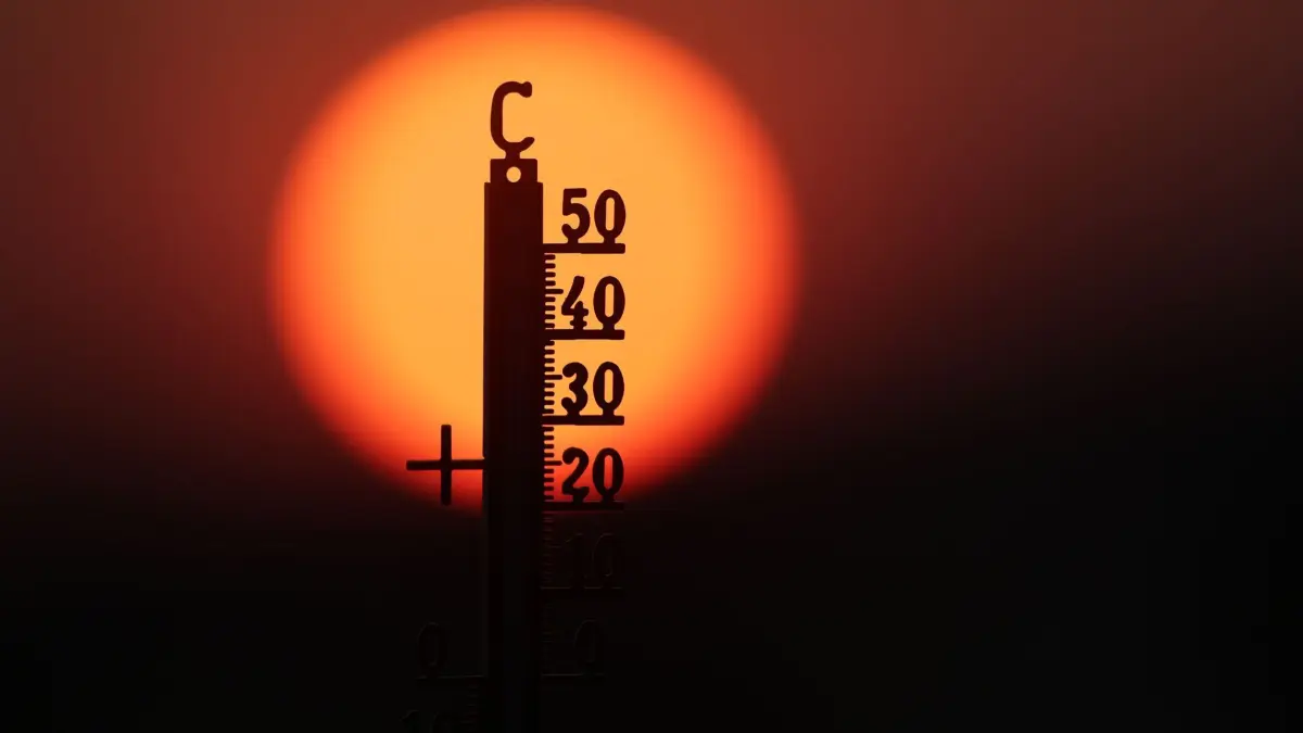 Hitze in Deutschland: ARCHIV - 21.06.2026, Baden-Württemberg, Unlingen: Hinter einem Thermometer geht am Morgen die Sonne auf. (zu dpa: «Hitze und Trockenheit führt zu Fischsterben») Foto: Thomas Warnack/dpa +++ dpa-Bildfunk +++