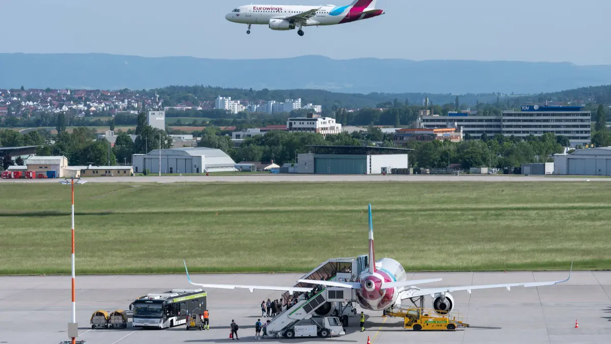 Zahlreiche Fluggäste steigen am Flughafen Stuttgart in ein Flugzeug der Fluggesellschaft Eurowings, während ein anderes Flugzeug von Eurowings im Landeanflug ist. Stuttgart Baden-Württemberg Deutschland *** Numerous passengers board a Eurowings aircraft at Stuttgart Airport while another Eurowings aircraft is approaching Stuttgart Baden Württemberg Germany