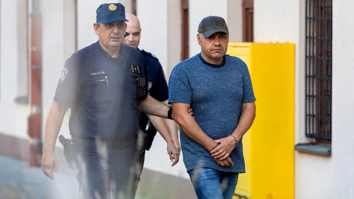 CROATIA-UKRAINE-RUSSIA-GERMANY-CONFLICT: Croatian police officers escort Ukrainian national Volodymyr Zhuravlov (C) a professional diver suspected of involvement in the 2022 Nord Stream pipeline sabotage, towards an appearance at The County Court in Pula, Croatia on August 20, 2026. A Ukrainian man was arrested on August 19, in Croatia on suspicion of taking part in the bombing of the Nord Stream gas pipelines running between Russia and Germany in 2022, German prosecutors said. The Federal Public Prosecutor's Office said the suspect, Volodymyr Zhuravlyov, a trained scuba diver, was arrested in Pula, Croatia, and was "strongly suspected of jointly causing explosions". (Photo by Srecko NIKETIC / PIXSELL / AFP) / - Croatia OUT - Bosnia and Herzegovina OUT - Serbia and Montenegro OUT - Slovenia OUT / ----IMAGE RESTRICTED TO EDITORIAL USE - STRICTLY NO COMMERCIAL USE-----