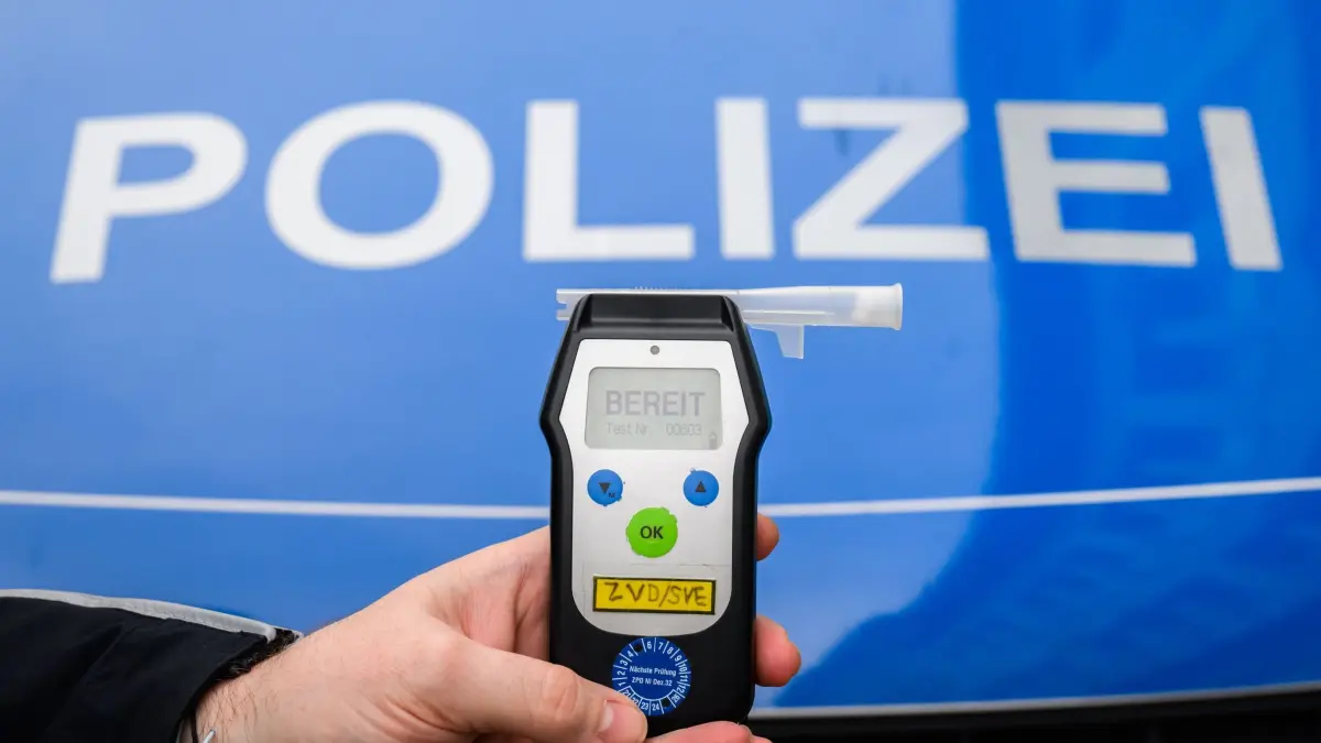 2,97 Promille am Steuer: ARCHIV - 28.01.2025, Niedersachsen, Hannover: ILLUSTRATION - Ein Polizist zeigt einen Alkoholtest (Atemtest), mit dem Verkehrsteilnehmer auf ihre Fahrtüchtigkeit hin überprüft werden können (gestellte Szene). (zu dpa: «Autofahrt mit 2,97 Promille - Beifahrerin schwer verletzt») Foto: Julian Stratenschulte/dpa +++ dpa-Bildfunk +++