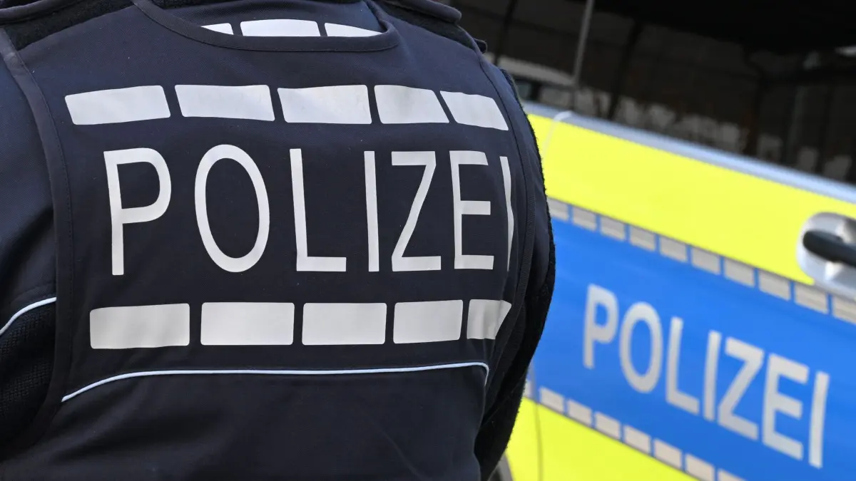 SEK-Einsatz in Lübeck: ARCHIV - 03.12.2024, Baden-Württemberg, Stuttgart: Der Schriftzug «Polizei» ist auf einem Einsatzfahrzeug und auf der Dienstkleidung der Polizei aufgebracht. (zu dpa: «Drohanruf bei Lübecker Bank - SEK nimmt Verdächtigen fest») Foto: Bernd Weißbrod/dpa +++ dpa-Bildfunk +++
