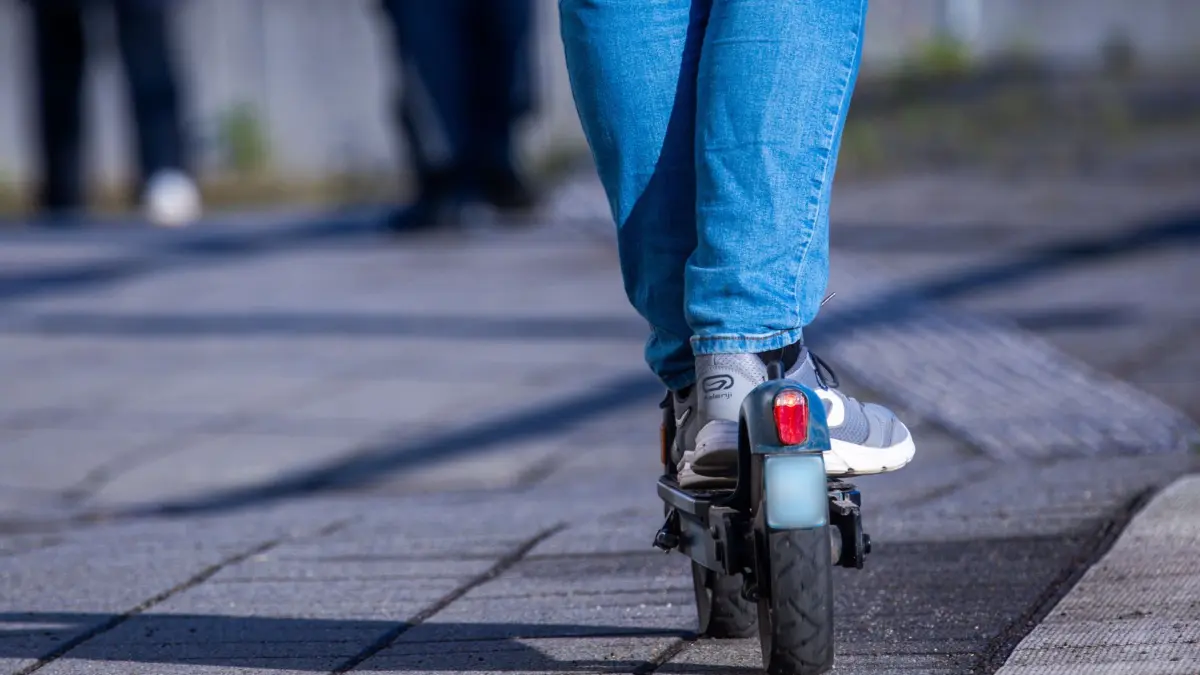 E-Scooter: ARCHIV - 17.04.2024, Mecklenburg-Vorpommern, Wismar: Ein Reisender fährt mit seinem E-Scooter über den Bahnsteig. (Symbolbild) (zu dpa: «Junger Mann auf E-Scooter bei Unfall schwer verletzt») Foto: Jens Büttner/dpa +++ dpa-Bildfunk +++