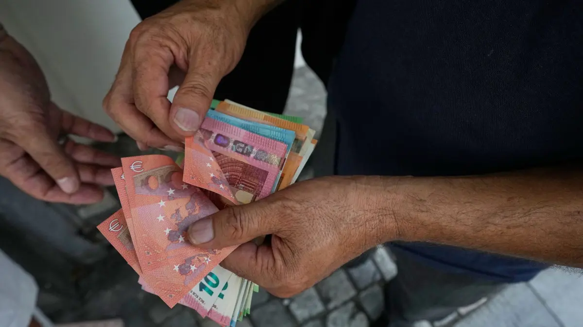 Alltag im Iran: 24.08.2026, Iran, Teheran: Ein Geldwechsler zählt Euro-Banknoten auf dem Ferdowsi-Platz, Teherans beliebtestem Ort für den Devisenumtausch. Foto: Vahid Salemi/AP/dpa +++ dpa-Bildfunk +++