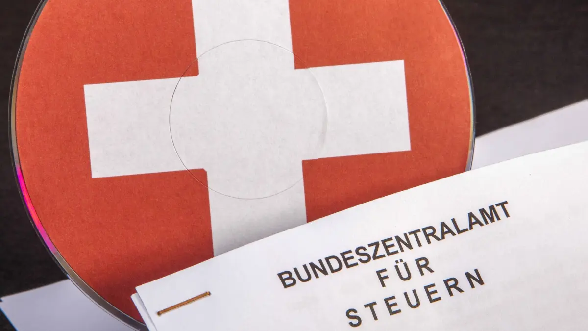 AUT, STUDIO AUFNAHMETISCH 2013-07-30 STEUERN, STAAT, WIRTSCHAFT: CD MIT SCHWEIZER FLAGGE, EUROZEICHEN UND RECHENSCHIEBER - STOCKFOTO ZUM THEMA STEUERFLUCHT, STEUERHINTERZIEHUNG ODER STEUEROASE SCHWEIZ