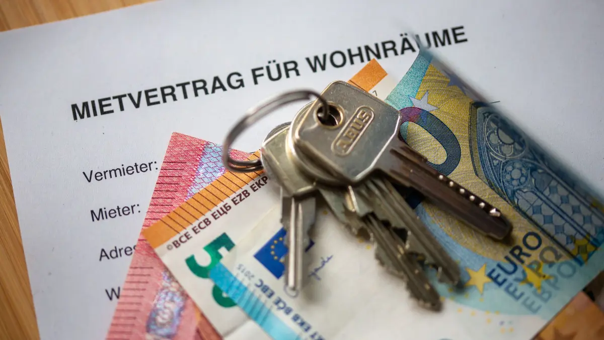 Mietvertrag, Geldscheine und Hausschlüssel auf einem Tisch