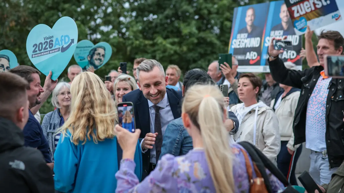GERMANY-POLITICS-VOTE-SAXONY-ANHALT-TV DEBATE: Far-right Alternative for Germany (AfD) party's main candidate Ulrich Siegmund greets supporters as he arrives for a debate on MDR regional TV in Magdeburg, eastern Germany on August 26, 2026. Saxony-Anhalt will go to the polls in the regional elections on September 6, 2026. (Photo by Ronny HARTMANN / AFP)