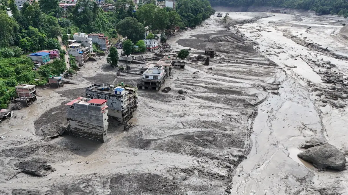 Nach Sturzfluten im nepalesischen Distrikt Nuwakot stehen beschädigte Häuser gefährlich nahe an den angeschwollenen, mit Treibgut verstopften Ufern des Trishuli-Flusses.