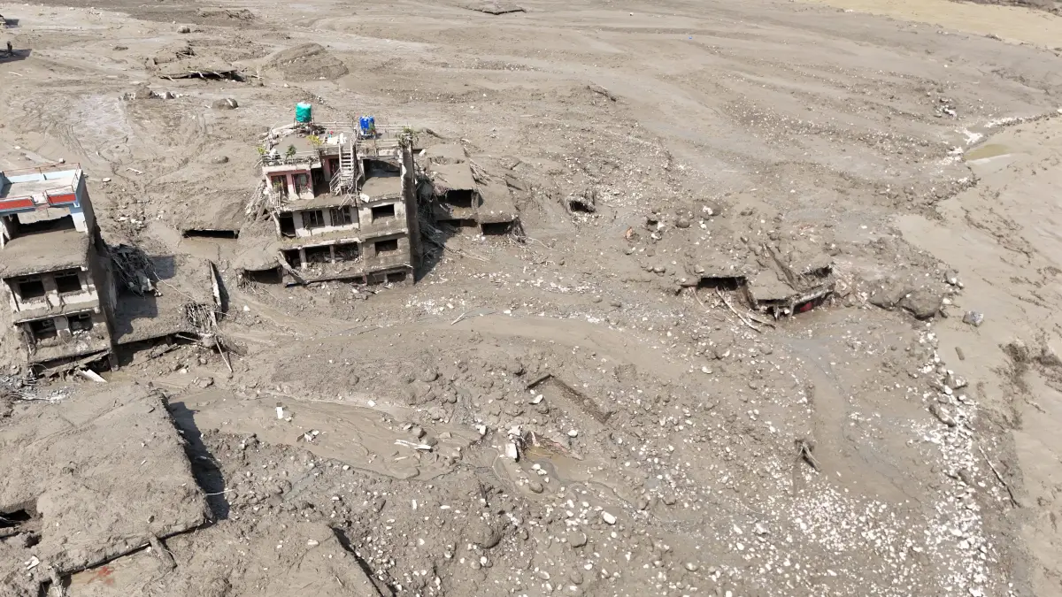 Beschädigte Gebäude und Infrastruktur entlang des angeschwollenen Trishuli-Flusses.