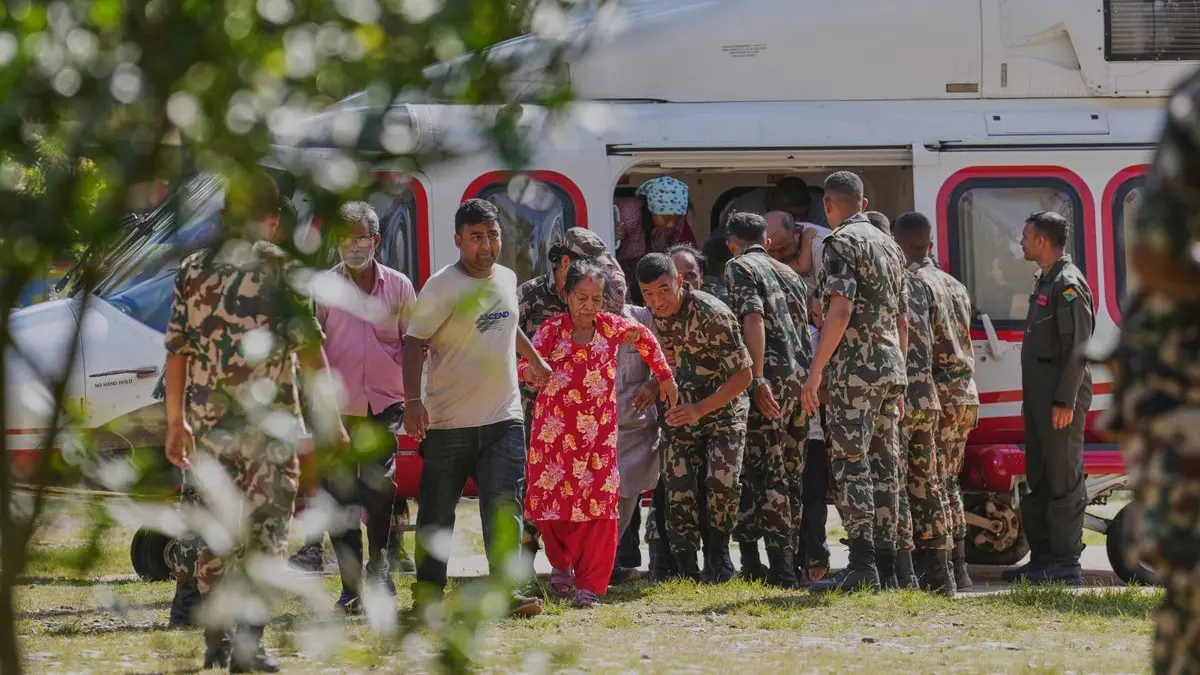 Soldaten der Armee helfen einer Familie beim Aussteigen aus einem Hubschrauber, nachdem sie aus einem von Sturzfluten betroffenen Gebiet im nepalesischen Distrikt Nuwakot gerettet wurden.