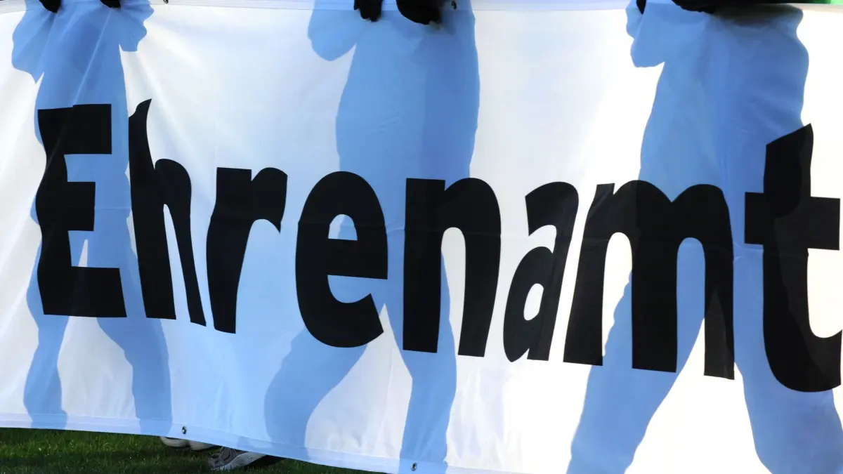 Ehrenamt: ARCHIV - 04.12.2010, Baden-Württemberg, Freiburg: Jugendliche halten vor einem Fußball-Bundesligaspiel ein Banner mit der Aufschrift «Ehrenamt» in den Händen. (zu dpa: «Rheinland-Pfalz feiert Ehrenamtliche in Kaiserslautern») Foto: Patrick Seeger/dpa +++ dpa-Bildfunk +++