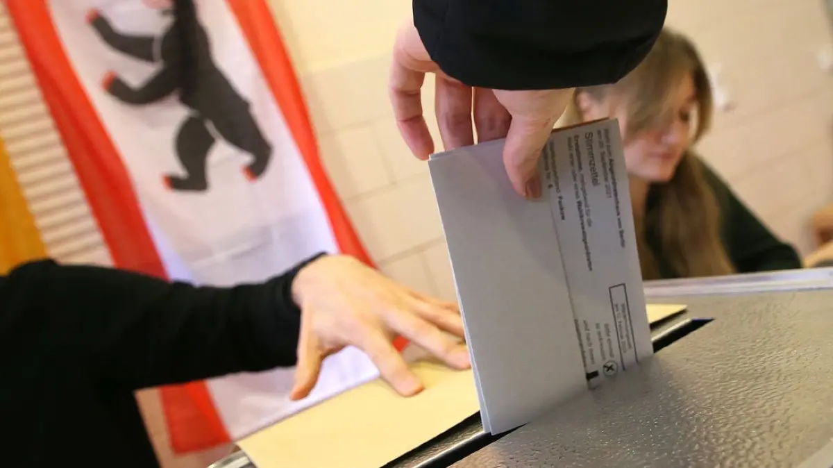 Eine Frau gibt ihre Stimme für die Wahl zum Berliner Abgeordnetenhaus ab und wirft ihren Wahlzettel in die Wahlurne.