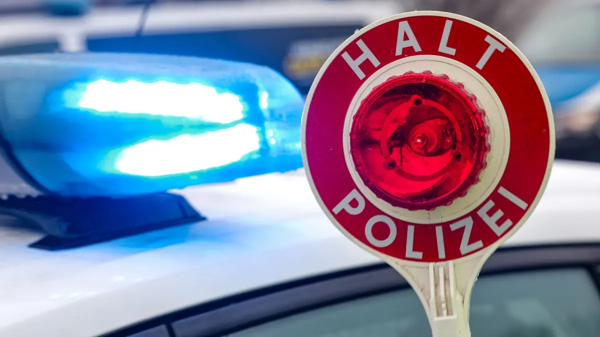 Polizeikontrolle: ARCHIV - 05.02.2025, Sachsen, Burgstein: Ein Polizist hält eine Polizeikelle für eine Kontrolle auf einem Parkplatz an der Autobahn. (zu dpa: «Polizei kündigt verstärkte Kontrollen im September in MV an») Foto: Jan Woitas/dpa +++ dpa-Bildfunk +++