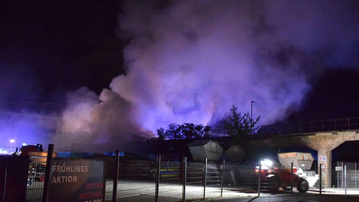 udwigsburg-Neckarweihingen, 3. September 2026 – In der Nacht zum Donnerstag, 3. September 2026, wurde der Integrierten Leitstelle des Landkreises Ludwigsburg gegen 2:00 Uhr ein groesserer Feuerschein auf einem Wertstoffhof im Ludwigsburger Stadtteil Neckarweihingen gemeldet.<br />
<br />
<br />
<br />
Umgehend wurden Einsatzkraefte der Feuerwehr Ludwigsburg zur Einsatzstelle entsandt. Vor Ort bestaetigte sich die Meldung. Es brannte Baustellenabfaelle in einer etwa 20 × 30 Meter grossen Box, die sich beim Eintreffen der Feuerwehr in voller Ausdehnung befand. Die offenen Flammen waren weithin sichtbar und erreichten eine Hoehe von etwa sieben Metern.<br />
<br />
<br />
<br />
Aufgrund der Groesse des Brandes wurden weitere Einsatzmittel, darunter ein Tankloeschfahrzeug zur zusaetzlichen Sicherstellung der Loeschwasserversorgung, an die Einsatzstelle beordert.<br />
<br />
<br />
<br />
Da sich die Einsatzstelle auf dem umzaeunten Gelaende des Wertstoffhofs befand, musste zunaechst ein geeigneter Zugang geschaffen werden. Anschliessend konnten die Feuerwehrfahrzeuge entsprechend positioniert und ein umfassender Loeschangriff eingeleitet werden. Dabei kamen mehrere bodengebundene Loeschrohre sowie ein Loeschrohr ueber die Drehleiter zum Einsatz.<br />
<br />
<br />
<br />
Parallel dazu wurde eine Loeschwasserversorgung aus dem nahegelegenen Neckar aufgebaut. Aufgrund der oertlichen Naehe bot sich diese Moeglichkeit zur Sicherstellung einer ausreichenden Wasserversorgung an.<br />
<br />
Im weiteren Einsatzverlauf wurde ein Teleskoplader der Feuerwehr Ludwigsburg an die Einsatzstelle nachgefuehrt. Mit diesem konnte das Brandgut auseinandergezogen und gezielt abgeloescht werden. Zusaetzlich stellte der Betreiber des Wertstoffhofs einen Bagger zur Verfuegung, der die Feuerwehr bei diesen Arbeiten unterstuetzte.<br />
<br />
<br />
<br />
Insgesamt waren drei bodengebundene Loeschrohre, ein Loeschrohr ueber die Drehleiter sowie ein Wasserwerfer im Einsatz. Zur Sicherstellung der Versorgung der eingesetzten Atemschutzgeraetetraeger wurde ausserdem der Abrollbehaelter Atemschutz an die Einsatzstelle gebracht.<br />
<br />
<br />
<br />
Nach rund einer Stunde hatte die Feuerwehr den Brand soweit unter Kontrolle, dass eine weitere Ausbreitung verhindert werden konnte. Die umfangreichen Nachloescharbeiten dauerten jedoch noch mehrere Stunden an.<br />
<br />
Aufgrund der bei den Loescharbeiten entstehenden Geruchsbelaestigung entschied sich der Fuehrungsdienst der Feuerwehr Ludwigsburg gegen 4:00 Uhr, eine Warnung ueber die entsprechenden Warn-Apps herauszugeben. Fuer die Bevoelkerung im Stadtgebiet Ludwigsburg bestand zu keinem Zeitpunkt eine Gefahr.<br />
<br />
<br />
<br />
Gegen 6:00 Uhr konnte der Brand vollstaendig geloescht werden. Anschliessend folgten noch abschliessende Kontroll- und Nachloescharbeiten.<br />
<br />
<br />
<br />
Die Feuerwehr Ludwigsburg war mit elf Fahrzeugen und 45 Einsatzkraeften rund viereinhalb Stunden im Einsatz. Ebenfalls vor Ort waren Kraefte des Polizeireviers Ludwigsburg sowie des Rettungsdienstes.<br />
<br />
<br />
<br />
Die Polizei hat die Ermittlungen zur Brandursache aufgenommen.