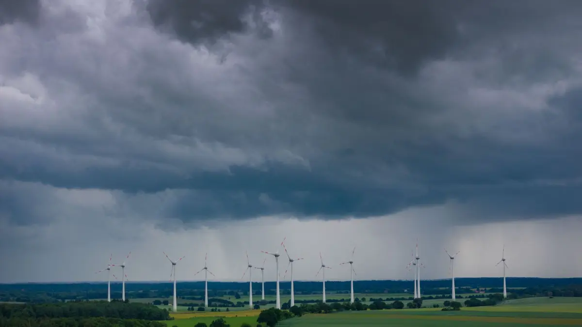 Gewitter über MV: ARCHIV - 04.06.2026, Mecklenburg-Vorpommern, Neuendorf: Dunkle Gewitterwolken ziehen über einen Windpark (Luftaufnahme mit Drohne). Der Deutsche Wetterdienst warnt in Mecklenburg-Vorpommern vor Hagel, Sturm und Starkregen. (zu dpa: «Regnerisches Wetter in MV: Wie sich der Tag entwickelt») Foto: Jens Büttner/dpa +++ dpa-Bildfunk +++